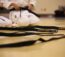 Fokus auf einige Schwarzgurte, die am Boden liegen, während dahinter die Beine von knienden Karateka zu sehen sind