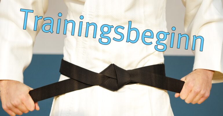 Grafik: Weißer Karate Gi, schwarzer Gürtel, blaue Schrift "Trainingsbeginn"